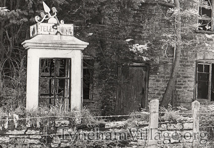The original white concrete telephone box outside Tyneham Post Office