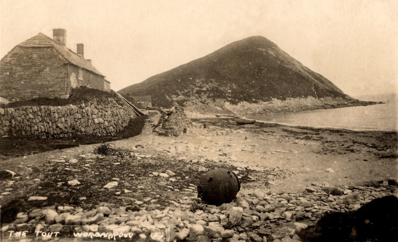 Historical photograph of Worbarrow Tout with Sea Cottage and fishing boats on the beach